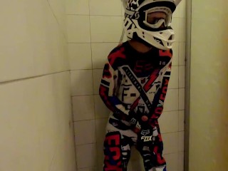 Восемнадцатилетний парень принимает душ в мотокроссовой экипировке и дрочит
