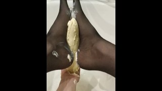 Doing footjob to giant butter dildo