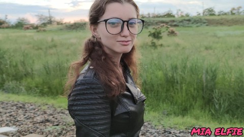 hermosa colegiala con una chaqueta de cuero y gafas camina en vuelos