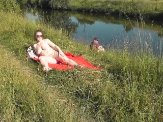 Riverside naked milf sunbathing is not_shy about random fisher.Outdoors. Wild beach. Public nudity