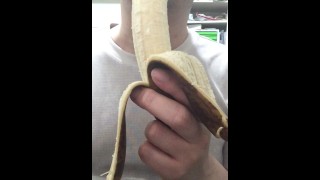 大きくて黒ずんだバナナを手で剥いて食べる