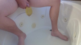 Pissing into a condom in the bathtub