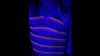 Asian Trans plays in blacklight rainbow