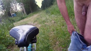Naked cyclist on a forest road