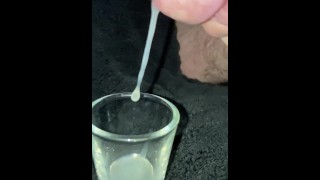 Super close up slow motion trying to cum into shot glass