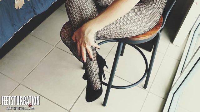 Shoe dangling with fishnets and black high heels