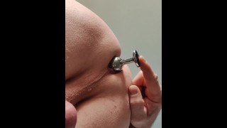 Locked slave plays with butt plug while his mistress is in the kitchen room