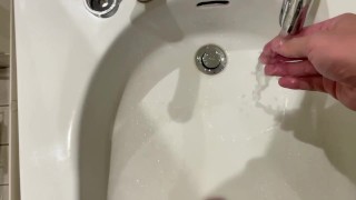 Pisser dans la zone de lavage des mains des toilettes publiques