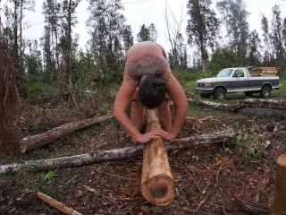 この素晴らしい世界の雨の中で丸太を叩き、足を裸のストレッチでこすります