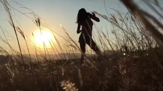 Dansen bij zonsondergang op blote voeten op blote borst naar de zon