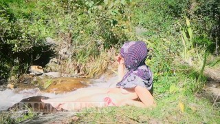 Schaamteloze moslim slet topless in hijab roken in de natuur