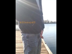 Pissing on the dock, at the river. Someone drives by...