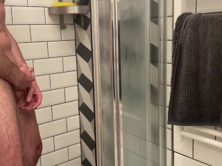 Stallion having a good time in the shower while watching Porn