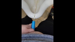 Fille utilise shewee pour pisser dans l’urinoir