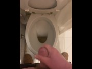 a guy pisses and then masturbates in the bathroom, cumming with his nice cock all over the place