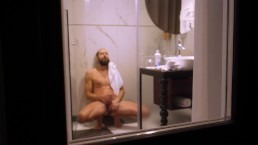 Rijpere kerel gefilmd van buiten terwijl hij een douche neemt en zijn harde lul aftrekt