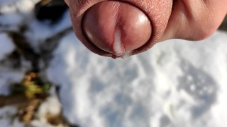 Primo piano sperma sulla neve e mostrando sperma nella neve