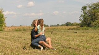 On The Field A Beautiful Teen Couple In Love Is Passionately Kissing