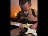 Guy with a ball gag plays guitar 