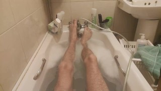 Mostrando mis pies y piernas delgadas y largas mientras toma un baño de burbujas
