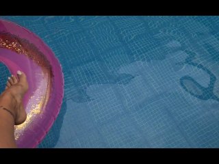 PLAYING WITH THE FEET ON THE SIDE OF THE POOL WITH THE BUOY