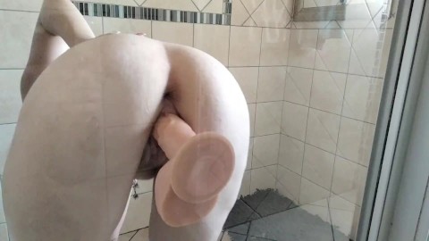 Youthful MILF fucking a suction cup dildo against the shower door until she orgasms