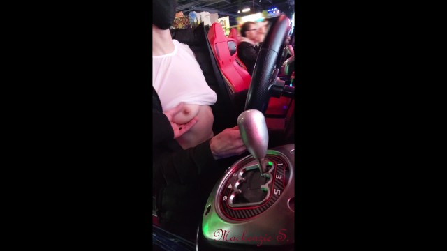Жена мигает рядом с незнакомцами в аркаде