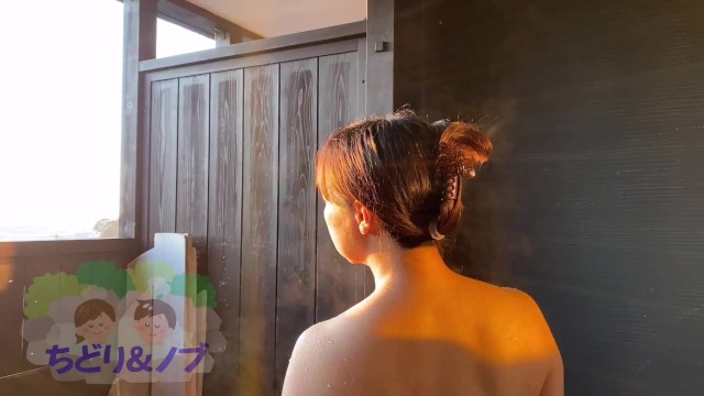 Японская женщина-любительница неторопливо принимает ванну в гостинице с горячими источниками с ванной под открытым небом.