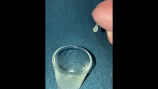 Close-up druipend sperma in shot glas slo-mo 