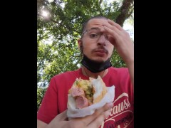 Eating a big hot dog at the park