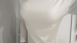 Le travesti aux faux seins porte un pull. Le soutien-gorge est visible à travers.
