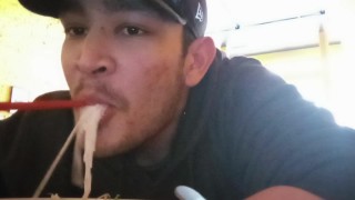 Joven asiático masculino se rellena la boca