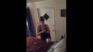 Hübsches Mädchen, das in ihrem Nachthemd raucht, während es fernsieht