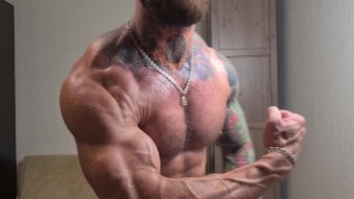 Jock tatuado se aceita y muestra los músculos