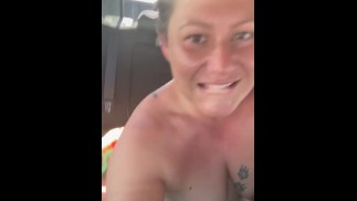 Sommersprossige dicke Amateur-Pfote Jez sitzt nackt auf der Ladefläche eines Lastwagens auf der Autobahn