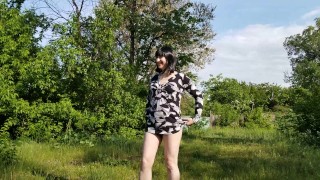 Красивая транс девушка собирает одуванчики на природе и показывает киску