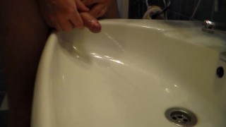 John is Peeing into the Bathroom Sink