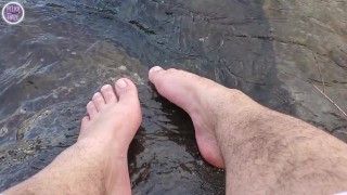 Grote voeten en harige benen spetteren op het strand