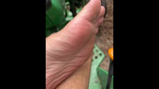 Vuile voeten op tractor hout snijden