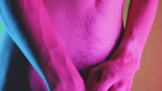 Movimentos sensuais no fundo colorido, mostrando protuberância e pau macio peludo