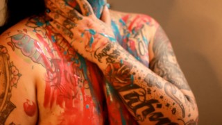 hermosa chica tatuada con caricias de pintura