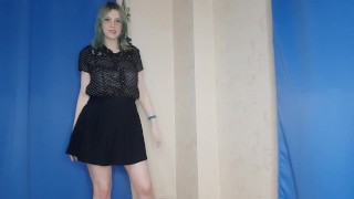 Uma garota de saia dança e se masturba com grampos nos mamilos