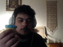 eating a blue frosted sprinkled cupcake from the local bakery