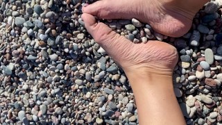 Pies relajantes Fetish en la playa rocosa Adoración de pies