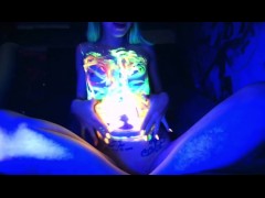 Petite flatchested  girl painting herself with blacklight paint 