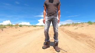 Jeans públicos molhando e inundando um par de botas de trabalho