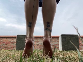 Slow motion milf barefoot in grass, wrinkled soles and red toes