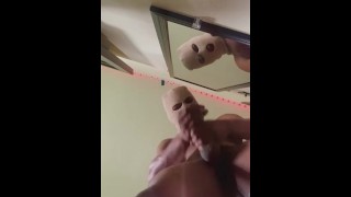 Hombre enmascarado en cumming en el espejo 