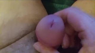 Gros plan d’une petite bite éjacule avec 2 doigts