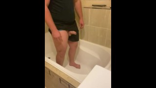 Guy wanhopig zijn plas in de badkuip houden, lekken en de controle verliezen
